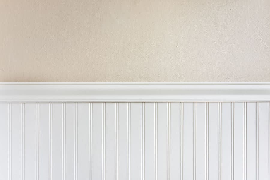 White baseboards, chair rail, and picture frame molding against freshly painted walls